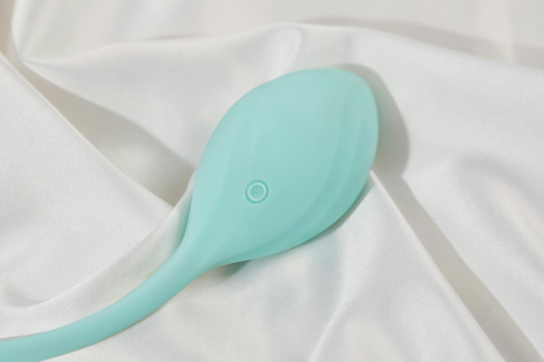 Lemon clitoral vibrator resting on soft white fabric, representing gentle pleasure without force
