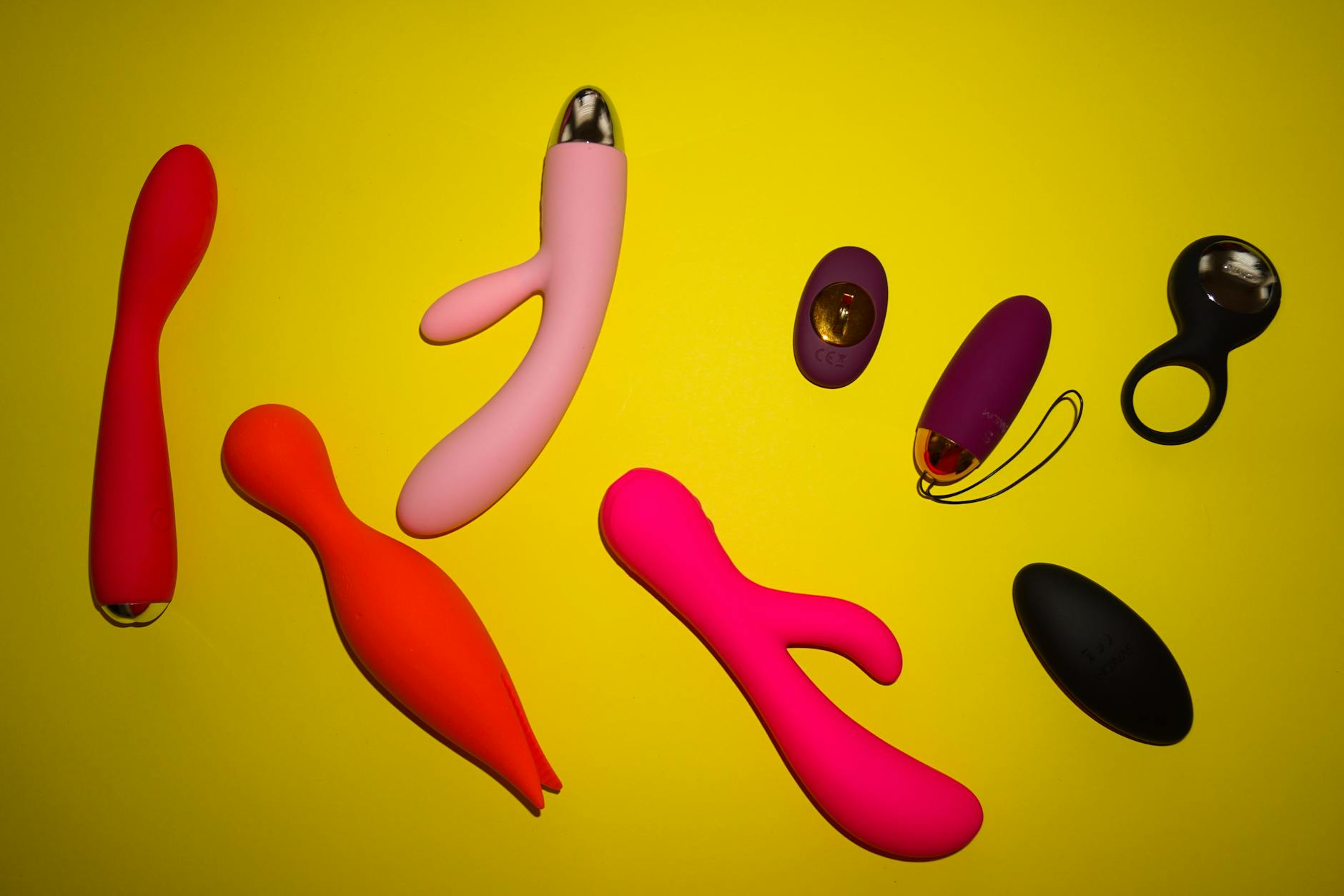 Collection of vibrant colorful sex toys arranged together showcasing diversity in pleasure devices