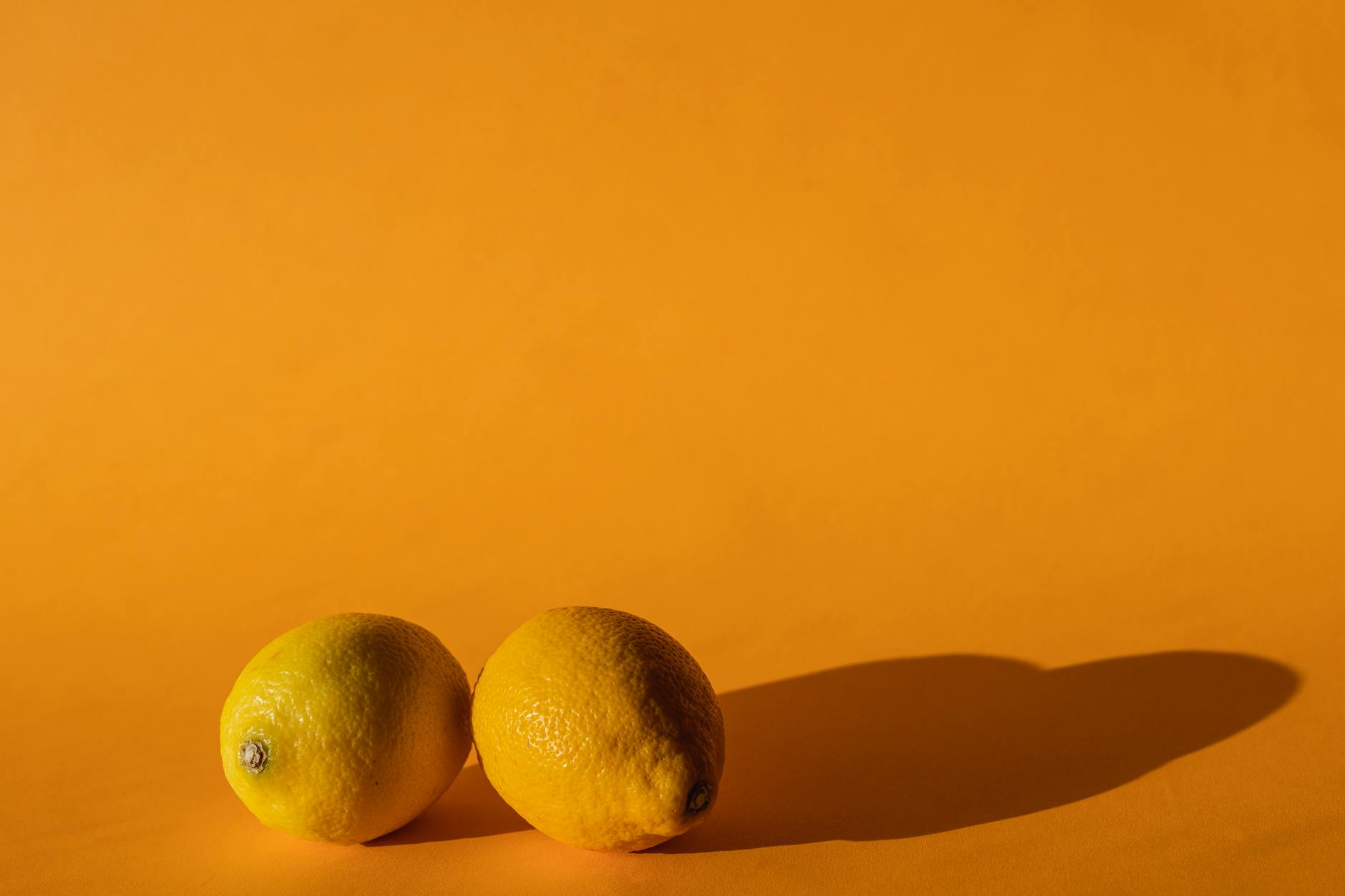 Fresh yellow lemons arranged on a bright yellow background, symbolizing renewed sensation and vitality