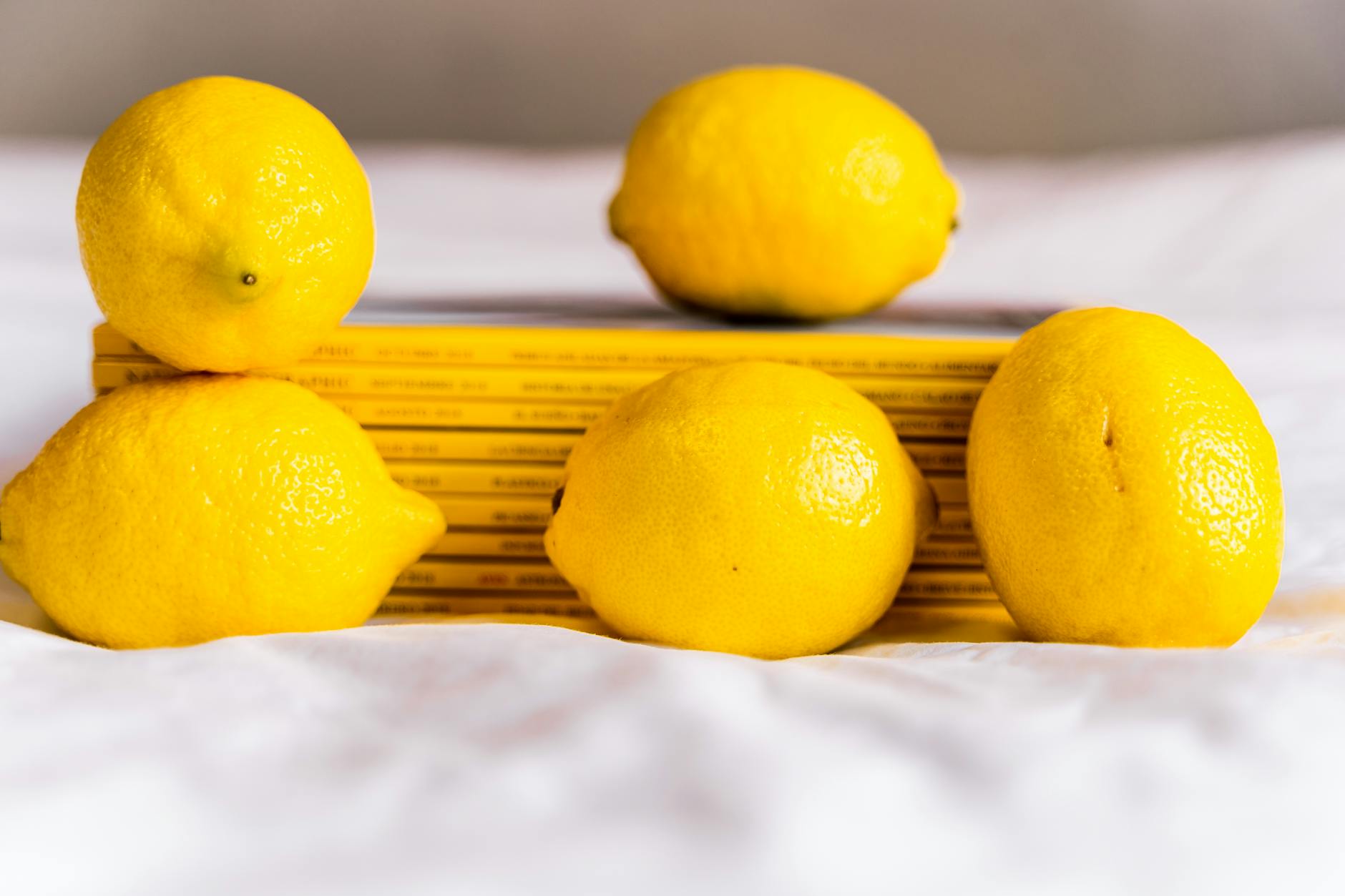 Yellow lemons arranged with books on white cloth, symbolizing fresh starts during recovery